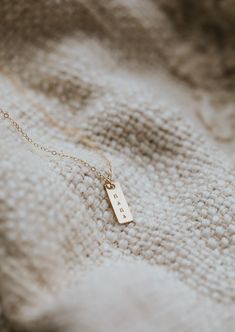 We updated our origina Mama Necklace to a shorter more modern bar design and added square pendant add-ons for the initials of your favorites. She’s still simple and minimal and full of very special meaning. Rectangle pendant measures 16mm long and is hand-stamped in a tiny uppercase block font. Bar is lightly brushed with steel wire for a matte finish. Our 6x9mm discs are hand-stamped with one heart or one initial per disc in an uppercase sans-serif font. Discs are suspended from a 16" or 18" de Minimalist Everyday Jewelry With Square Pendant, Square Minimalist Jewelry For Everyday, Minimalist Necklace With Rectangular Links Gift, Everyday Jewelry With Rectangular Pendant Box Chain, Minimalist Rectangular Link Necklace As Gift, Personalized Gift Rectangular 14k Gold Jewelry, Classic Rectangular Jewelry For Personalized Gifts, Minimalist 14k Gold Bar Necklace For Anniversary, 14k Gold Rectangular Charm Necklaces As Gift