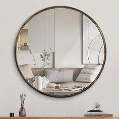 a round mirror hanging on the wall above a table