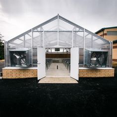 an open air building with several windows on the front and back sides, in a parking lot