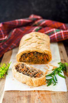 a meat filled pastry sitting on top of a wooden cutting board