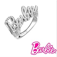 Elevate your style with our stunning 925 sterling silver Barbie ring. This exquisite piece features the word “Barbie” elegantly crafted in sparkling gemstones, creating a dazzling and glamorous accessory perfect for any fashion-forward individual. The ring’s intricate design and shimmering details make it a standout piece in any jewelry collection. Shipping:Takes 5-8 business days depending on stock, these beautiful rings are custom sized and made in small batches. If your size is in stock this item will ship immediately Product Details: Material: 925 Sterling Silver Gemstones: Clear Cubic Zirconia Design: Sparkling “Barbie” lettering Finish: Polished Size: Adjustable Occasion: Everyday wear, parties, and special occasions Why Choose This Ring? Elegance: The combination of sterling silver Glamorous White Gold Ring, Luxury Party Diamond Ring With Sparkling Stones, Luxury Diamond Ring With Sparkling Stones For Party, Luxury Sparkling Rings For Party, Glamorous Open Ring Jewelry For Party, Luxury Sparkling Party Rings, Glamorous Bling Rings For Formal Occasions, Glamorous Formal Rings With Bling, Party Jewelry With Diamond Accents On Open Ring