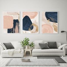 two abstract paintings hang on the wall above a white couch in a modern living room