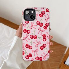 a person holding up a phone case with cherries on it