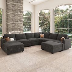 a living room with large windows and a sectional couch in the middle of the room