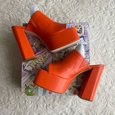 Brand New, Never Used Only Tried On In Store. Size Is 9.5 But Fits A 9-9.5, I’m A 9 And They Fit Me! Fall In Luv With The The Luna Luv Platform Mule In Orange! These Chunky Open-Toe Platforms Are Both Playful And Elevated, And Pair Perfectly With Any Flare Style Pant. Pair It With A Light Washed Jean For A Daytime Look Or Channel Your Y2k Vibes And Pair Them With Your Favorite Mini Skirt! Faux Leather Upper With Manmade Sole Slip-On Styling Leather Lining Approx 5.25 Inch Heel Approx 2 Inch Plat Modern Orange Heels With Padded Heel, Trendy Orange Open Toe Heels, Modern Orange Open Toe Heels, Trendy Orange Wedge Heels, Casual Orange Platform Heels, Spring Orange Leather Heels, Orange Platform Heels With Synthetic Material, Orange High Heel Platform Shoes, Orange Platform Heels With High Heel