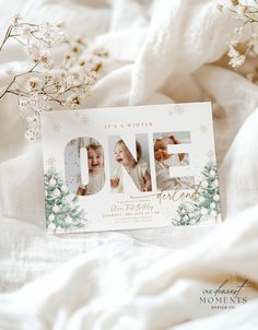 a one year birthday card on top of a bed with flowers and baby's breath