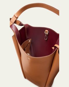 Tod's bucket bag in grained calf leather     Fixed top handles, 12.6" drop     Hook closure     Removable pendant with branded metal T Timeless accessory    Interior, two slip pockets     Lining: Leather/nylon/polyurethane    Approx. 12.6"W x H 11.8"H x 4.7"D    Made in Italy Brown Calf Leather Bucket Bag With Handle Drop, Workwear Bucket Hobo Bag With Detachable Handle, Smooth Grain Top Handle Bucket Bag For Work, Luxury Tan Bucket Bag For Everyday Use, Smooth Grain Bucket Bag For Work, Calf Leather Bucket Bag With Smooth Grain, Pebbled Leather Bucket Bag With Detachable Strap, Luxury Tan Bucket Bag With Double Handle, Classic Smooth Grain Bucket Bag For Work