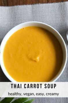 a bowl of creamy thai carrot soup on a table