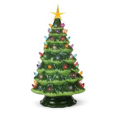 a green ceramic christmas tree with lights on it's sides and a star above the top