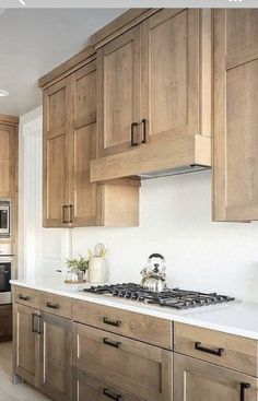 a kitchen with wooden cabinets and white counter tops, along with a stove top oven