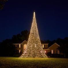 a lighted christmas tree in front of a house