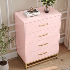 a pink chest of drawers next to a potted plant