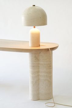 a table with a lamp on top of it and a cord running through the middle