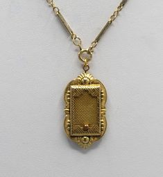 This is a antique gold filled locket made by the JJ White company. This company began business in 1896. I believe this locket is from around the turn of the century. The locket has a sliding mesh door that hides a picture within. I have paired it with a nice gold filled chain that appeared to have some age also. The locket is 1 3/4 by 7/8 inches, the chain is 19 inches. This necklace is in very good to excellent condition for its age with minimal signs of wear to the gold filled plating. The mesh door slides easily and it retains the original photo holder. This beautiful piece of history will arrive in a black velvet pouch. Free shipping. Victorian Gold Rectangular Necklace, Victorian Rectangular Gold Necklace, Victorian Gold Locket Necklace With Vintage Charm, Victorian Filigree Locket Necklace In Yellow Gold, Victorian Filigree Yellow Gold Locket Necklace, Victorian Yellow Gold Locket Necklace With Filigree, Heirloom Antique Gold Locket Necklace With Antique Finish, Heirloom Antique Gold Locket Necklace, Victorian Engraved Rectangular Necklace