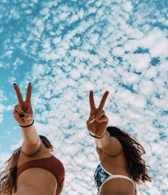 two women in bikinis making peace signs with their hands