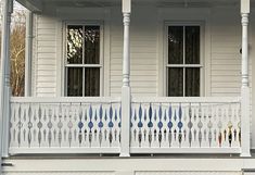 the front porch of a house with white balconies