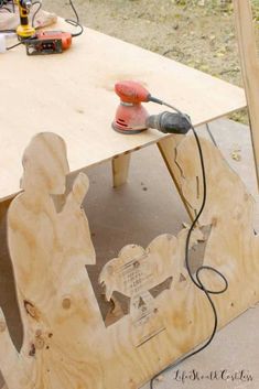 a work bench made out of plywood is being worked on with a power drill