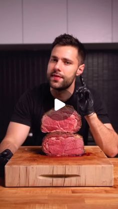 a man sitting at a table with some raw meat on top of it in front of him