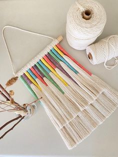 several skeins of yarn are laid out on a table next to some spools of thread