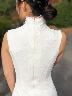 the back of a woman's wedding dress, with her hair in a low bun