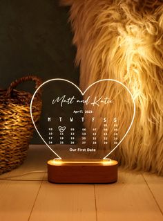 a heart shaped desk calendar on top of a wooden table