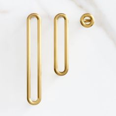 two brass handles on a white marble surface