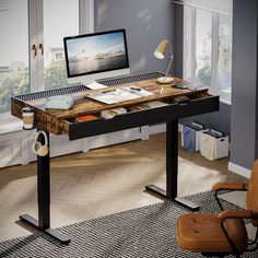 a computer desk with a monitor and keyboard on it in front of a large window