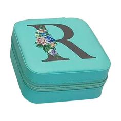 the letter r is painted on top of a blue box with flowers and leaves in it