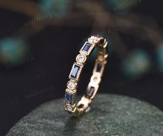 a diamond and sapphire ring on top of a rock