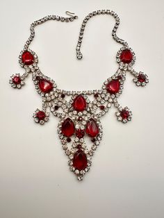 Vintage  Huge Red and Clear Rhinestone Bib Necklace, matching pierced earrings and Bracelet, the glamorous glitzy bib style necklace has an elaborate design made with enormous ruby red glass teardrops, each outlined with Red Rhinestones, and large round red rhinestones, also outlined with clear rhinestones. Necklace Matching, Bib Necklaces, Red Rhinestone, Bib Necklace, Style Necklace, Pierced Earrings, Red Glass, Clear Rhinestones, Ruby Red