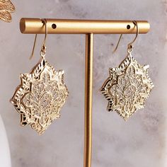 Discover the allure of our Filigree Geometric Oriental Design Gold Earrings, where intricate craftsmanship meets timeless elegance. These exquisite earrings showcase a stunning geometric pattern inspired by oriental art, crafted in shimmering gold. Lightweight and comfortable, they are perfect for everyday wear and special occasions. Elevate any outfit with their unique style, making them an ideal gift for someone special or a luxurious treat for yourself. Length 45 mm, 1 ¾ in, Widht 25mm, 1 in, Elegant Yellow Gold Geometric Earrings, Elegant Geometric Earrings As Gift, Elegant Geometric Earrings For Gifts, Elegant Geometric Pierced Earrings, Elegant Geometric Gold Earrings, Elegant Gold Geometric Earrings, Gold Brass Chandelier Earrings With Intricate Design, Gold Metal Filigree Chandelier Earrings, Gold Metal Chandelier Earrings With Filigree Detail