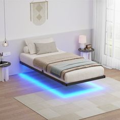 a bed that has some lights on the side of it and is in a room with white walls