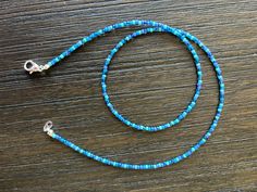 This beaded necklace is made with different shades of blue Toho seed beads. Each necklace will be unique in that the beads will be chosen randomly.