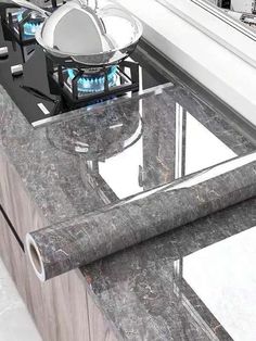 a marble counter top next to a sink in a room with white walls and windows