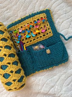 two crocheted items are sitting on the bed next to each other, including a book and pen holder