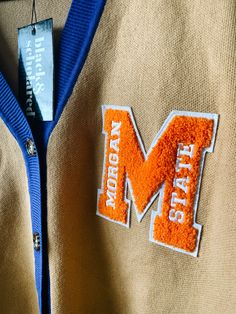 Make a bold statement and wear your Morgan State pride with this one-of-a-kind and comfortable cardigan sweater, perfect for any alumni, students or supporters. Made with the highest quality materials, this sweater is designed to keep you warm and cozy while representing Morgan State. Features:- Official Morgan State University logo embroidered on the chest- Large "M" Chenille patch- Classic cardigan design with a tortoise shell button-up front- Two front pockets (deep enough to fit a phone and Collegiate Cardigan For College In Fall, Collegiate Fall Cardigan For College, Fall Collegiate Style College Cardigan, Collegiate Style Cardigan For Fall College Season, Collegiate Style Fall Cardigan For College, Collegiate Long Sleeve Cardigan For College, Long Sleeve Collegiate Cardigan For College, Winter College Cardigan, Collegiate Long Sleeve Cotton Cardigan