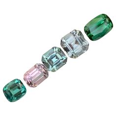 five different colored diamonds are shown in this image, one is green and the other is pink