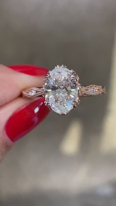 a woman's hand holding an engagement ring with two oval diamonds on the band