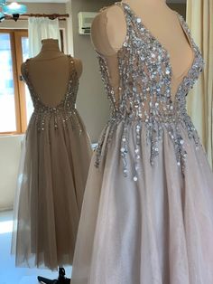 two dresses on mannequins, one in grey and the other in beige