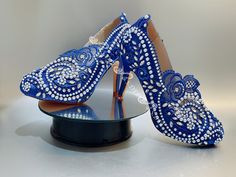 a pair of blue high heeled shoes sitting on top of a table