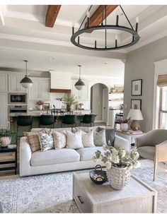 a living room filled with furniture next to a kitchen