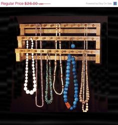 a wooden rack with several necklaces hanging from it