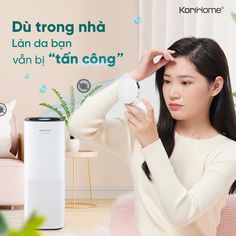 a woman is holding her hair in front of an air purificater