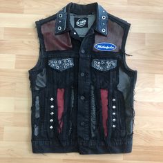 Denim Hard Rock Punk vest made by Lone Gunman Clothing. Leather and denim patchwork for a unique rock n roll look. Hours of details for this one of a kind piece. The bozo backprint is cut out of an offical merchandise product. Size Medium. Armpit to armpit approx 48cm. Punk Style Vest For Streetwear In Fall, Punk Style Denim Vest For Fall Streetwear, Punk Denim Vest For Fall Streetwear, Rocker Style Fitted Vest For Streetwear, Edgy Distressed Denim Jacket For Alternative Fashion, Edgy Denim Vest For Fall Streetwear, Edgy Black Vest For Festival, Fitted Grunge Vest For Festivals, Edgy Black Festival Vest