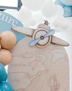 balloons are in the shape of an airplane on top of a map and balloon garland