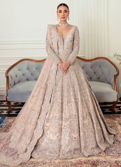 a woman standing in front of a couch wearing a wedding dress