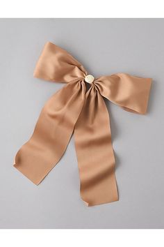 the large satin bow is tied on top of a gray surface with a white button in the center