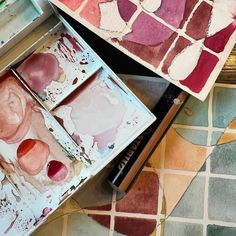 some watercolors are sitting on a table next to an artist's palette