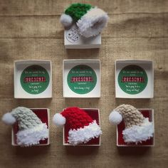 four small christmas hats in boxes on a table