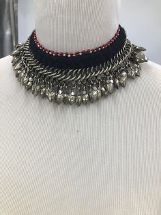 * This beautifully handcrafted silver color shade necklace is the epitome of tradition. The metallic weaving technique and dangling beads at the bottom are flaunting all the tribal vibes. The thread work at the top has complimented the whole theme of the necklace. You can pair this elegant piece of craft with any traditional or trendy outfit. Note: The product is handmade, slight change might occur in the actual product. Handmade Traditional Silver Beaded Necklaces, Handmade Silver Traditional Beaded Necklaces, Traditional Handmade Silver Beaded Necklaces, Handmade Silver Beaded Traditional Necklace, Silver Dangle Bohemian Choker, Silver Bohemian Dangle Choker, Festival Adjustable Silver Beads Necklace, Black Bohemian Necklace For Celebration, Traditional Necklace With Dangling Beads